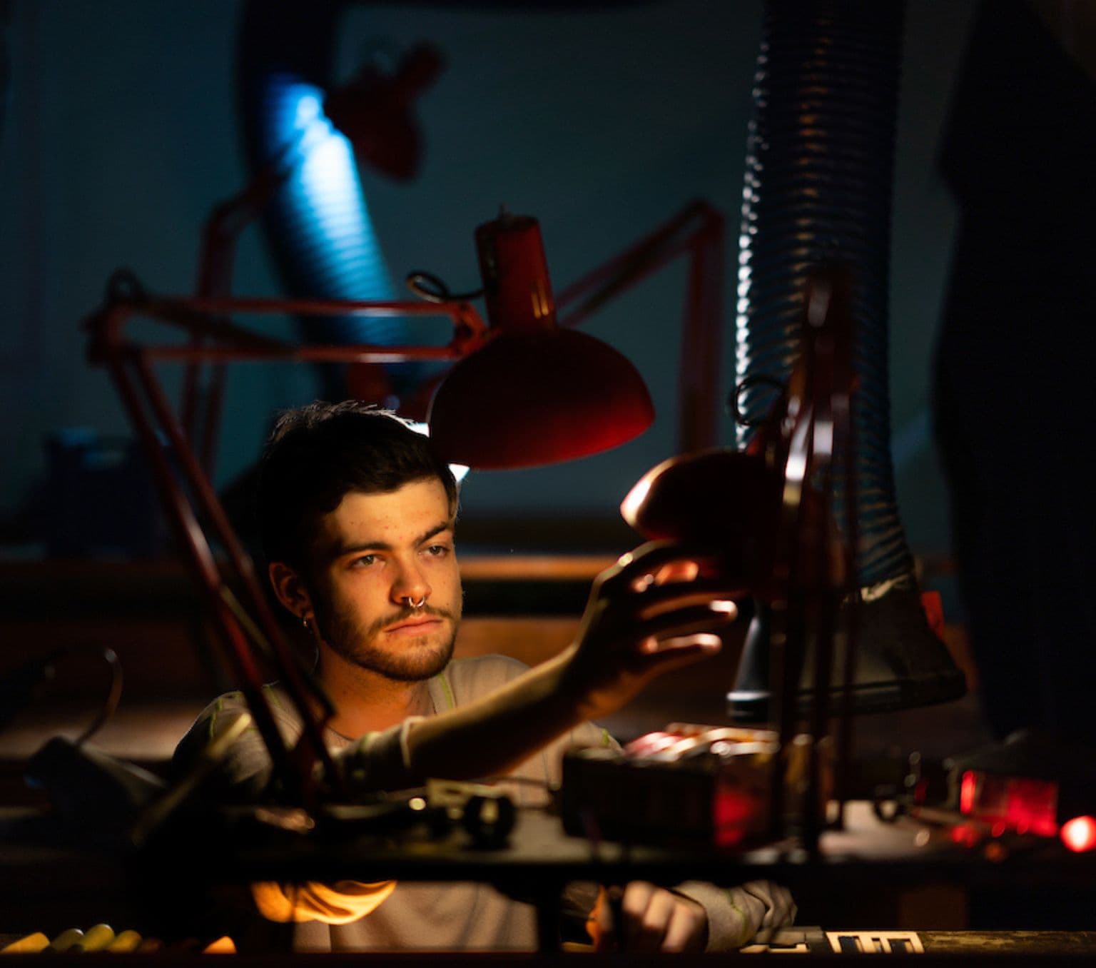 Photo of jewellery maker Jonathon Zalakos sitting at his work bench.