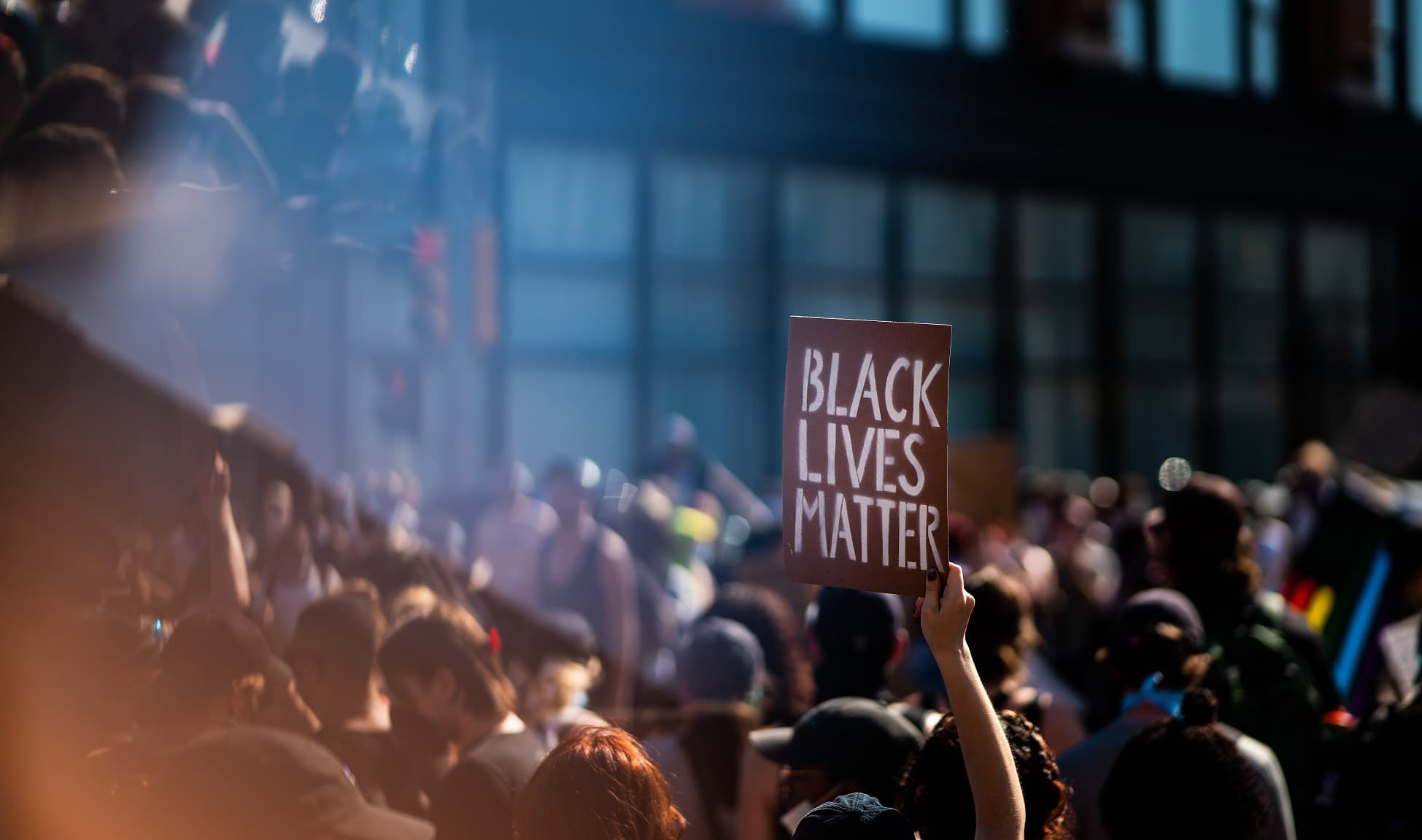 Sign reading Black Lives Matter is held up among a crowd of people