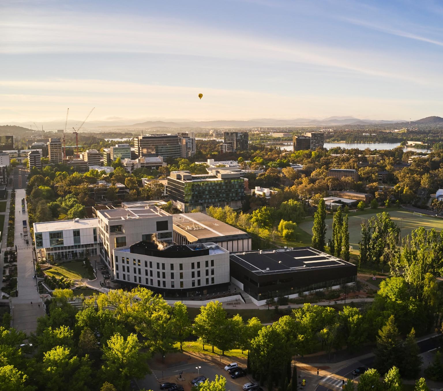 buildings and trees with a hot air balloon in the background from an aerial view