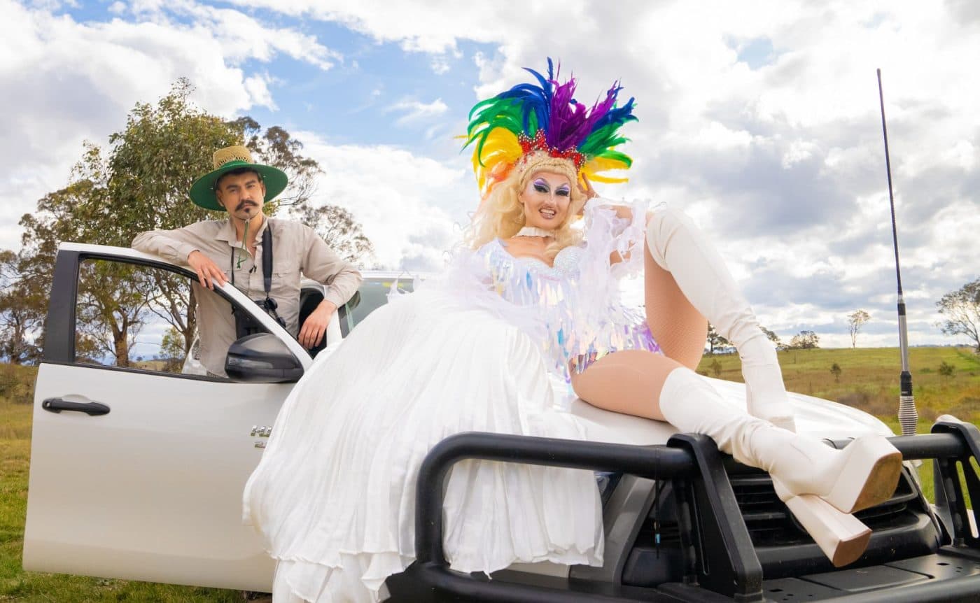 A combination of drag queens, ballet dancers and Brazilian funk dancers wearing colourful costumers filled to the brim with sequins. They are all dancing in a field in regional Victoria.