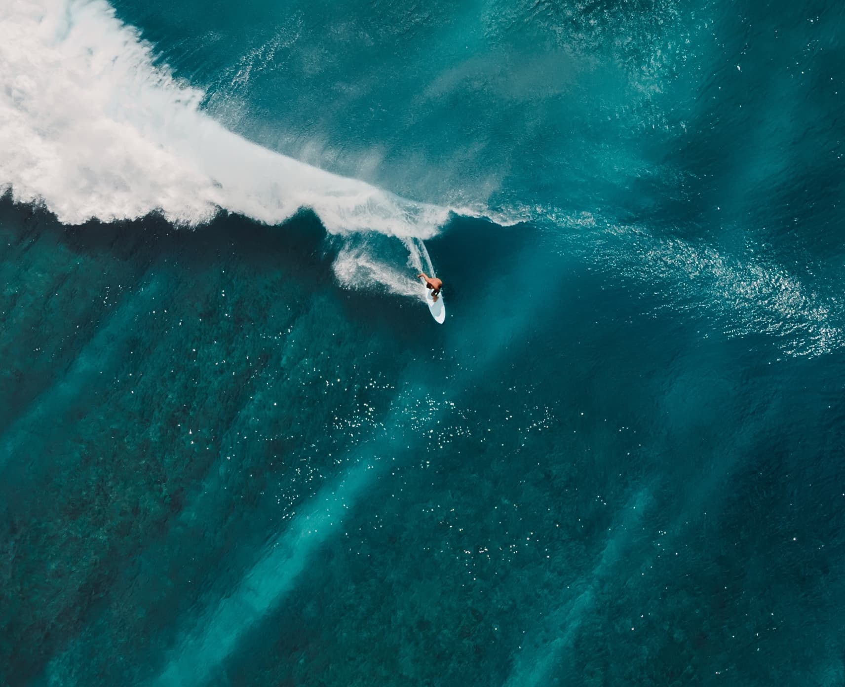 An aerial view of a surfer riding a wave