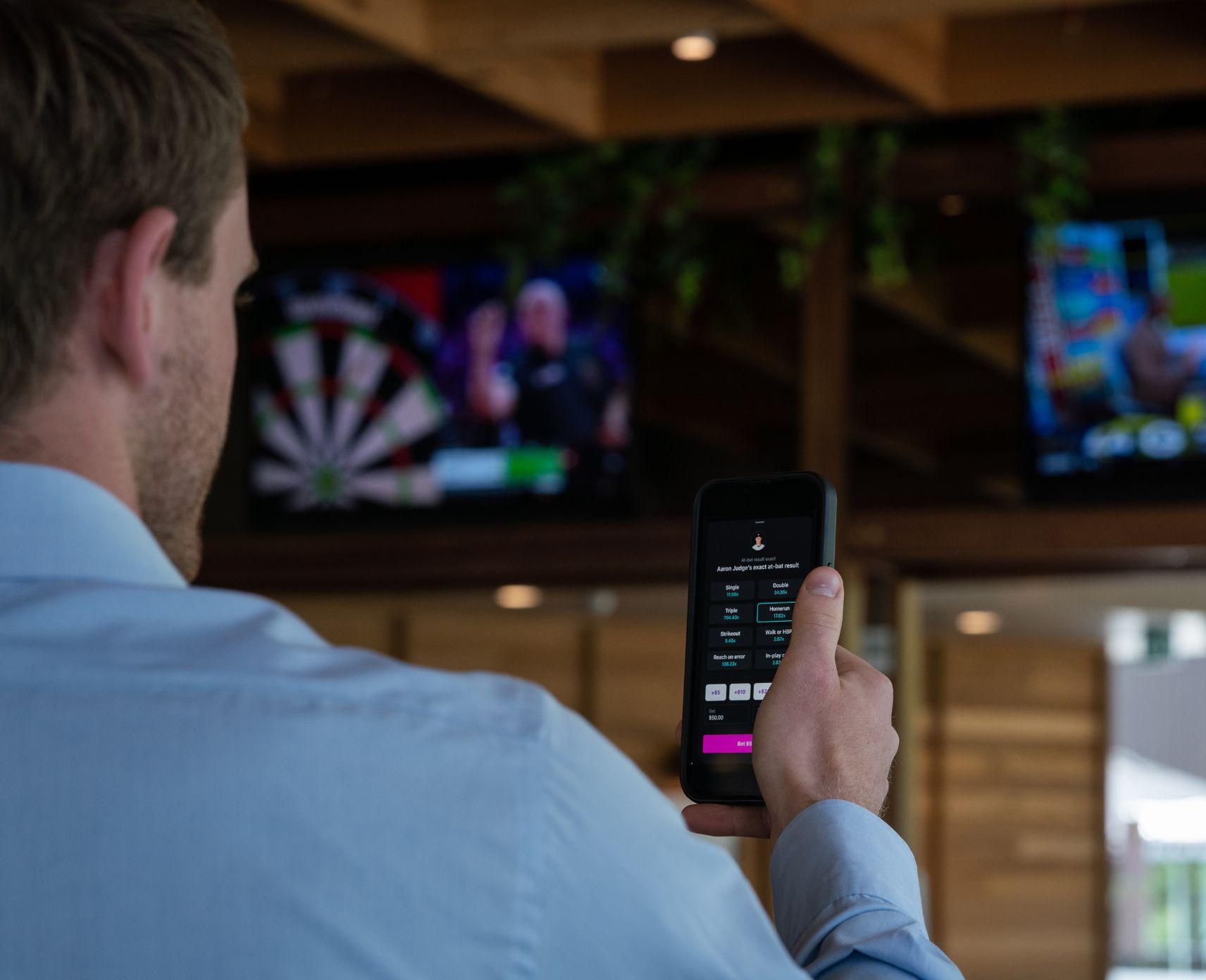 Man watching sport with phone betting