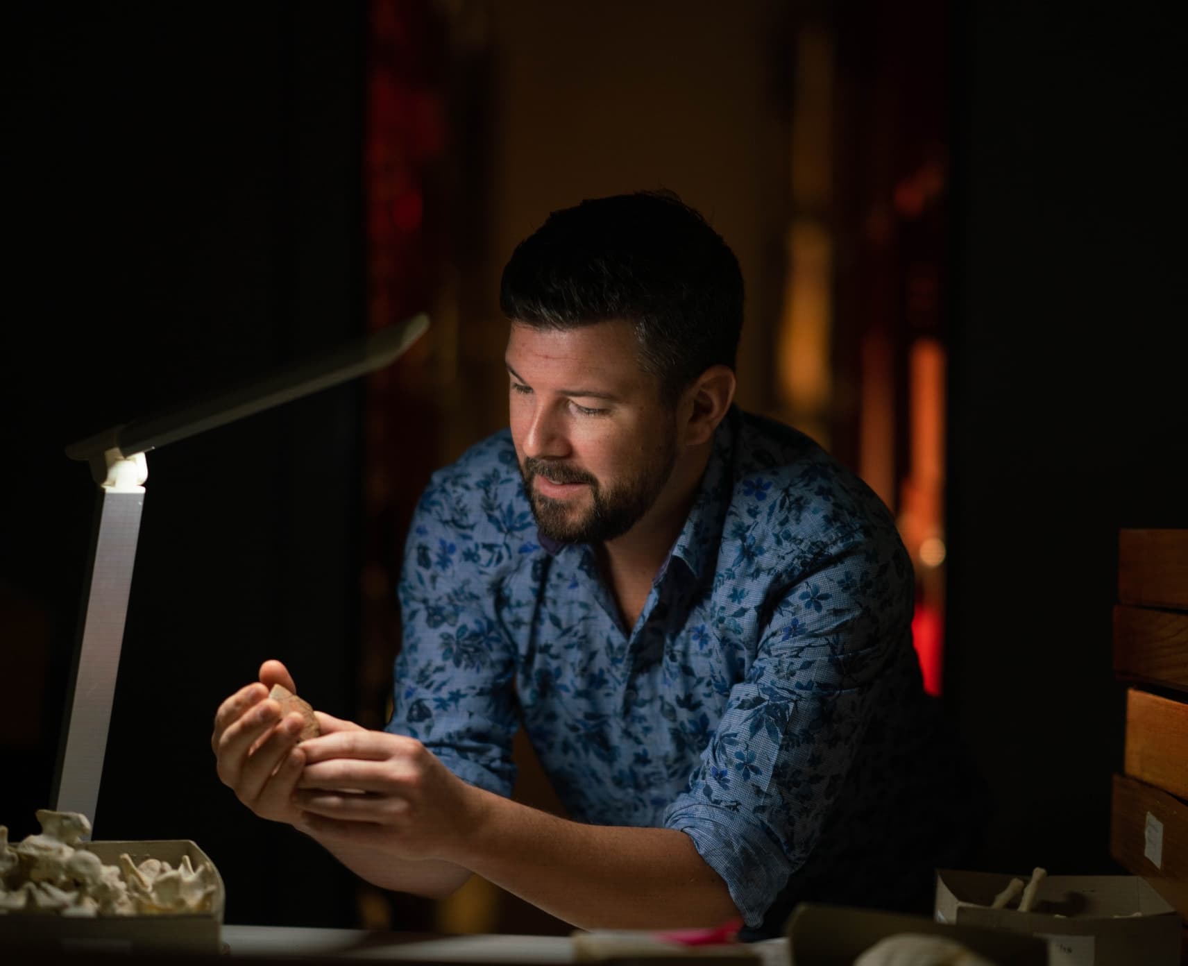 Dr Ben Shaw inspects a pottery shard from PNG. He has recently returned burial pots to PNG