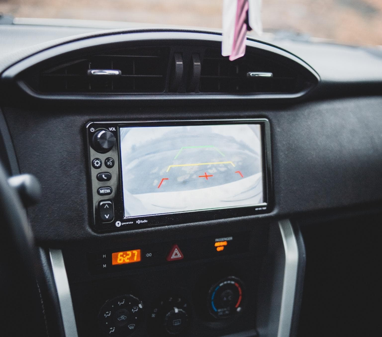 view of the control centre of a car. There is a screen with a reversing camera.