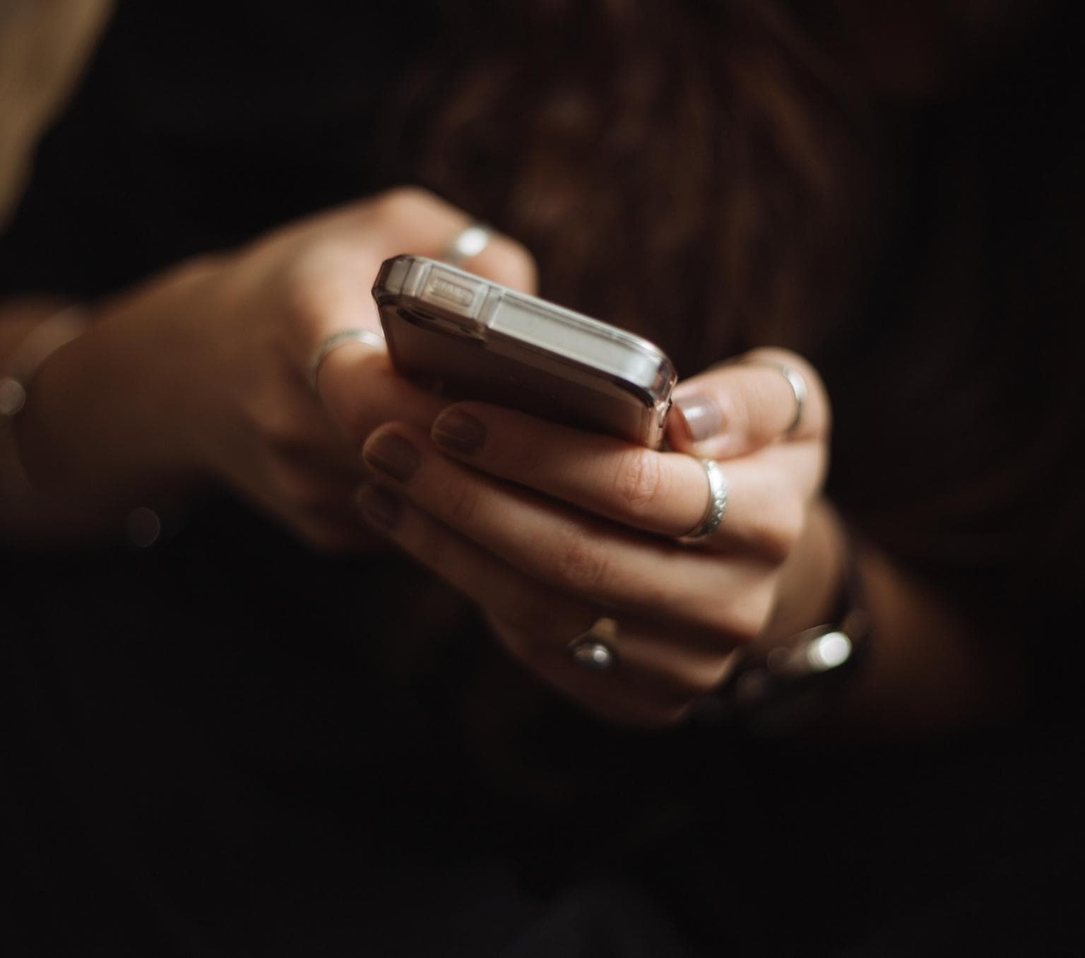 An unidentified person holding a phone with two hands