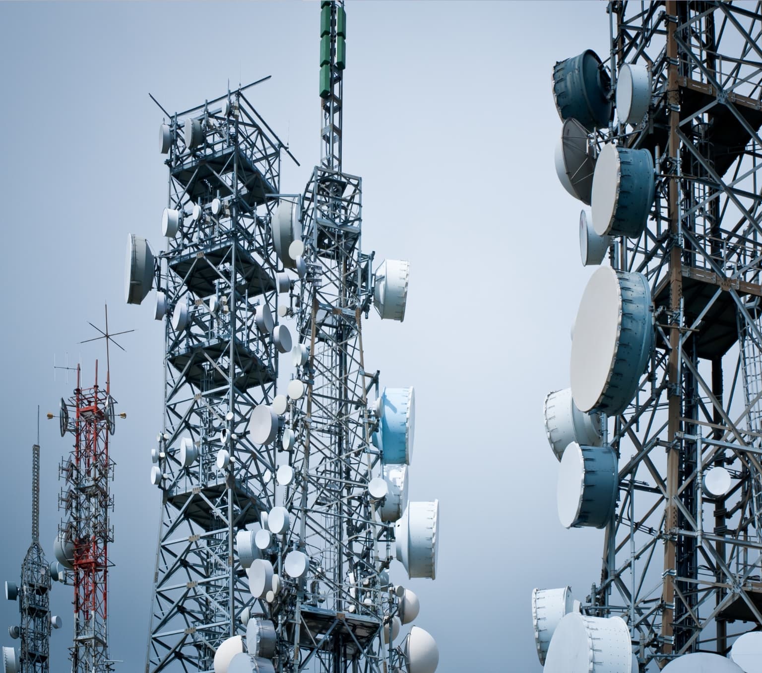large metal tower frames in the sky with white drum structures placed around the frames