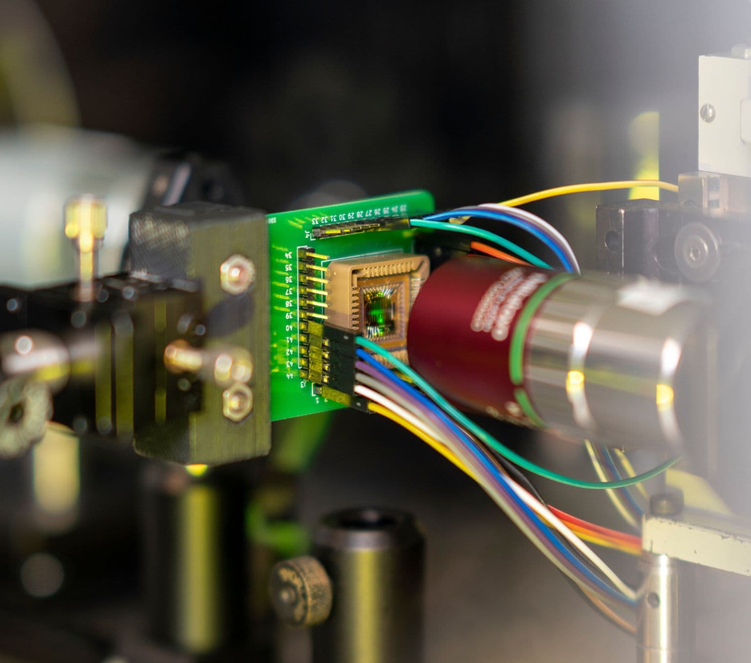 A piece of machinery with a green centre with wires emerging.