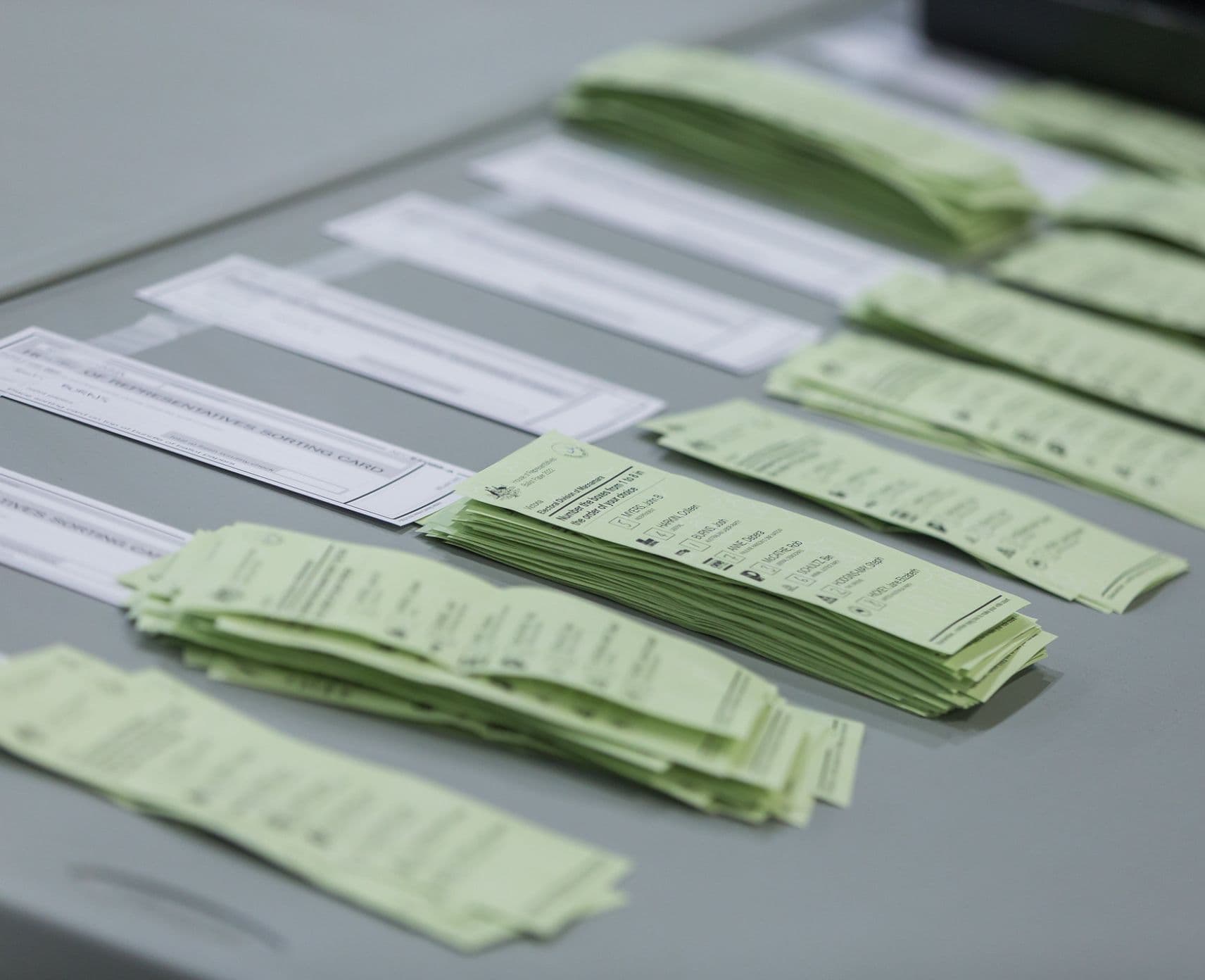 Piles of House of Representative ballot papers on a fold-out table