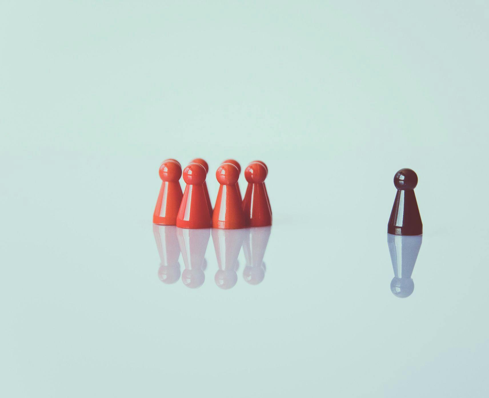 Red figurines together, black figurine alone