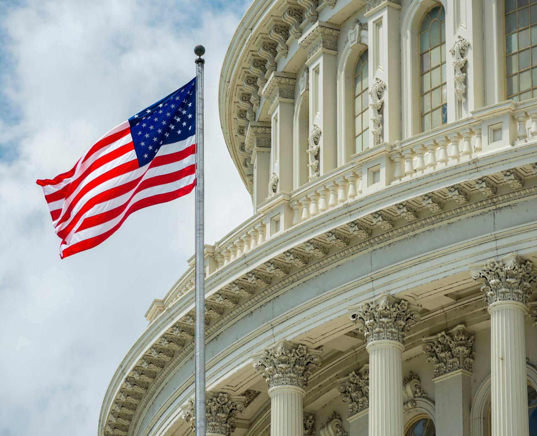 The US flag next to the Capitol building