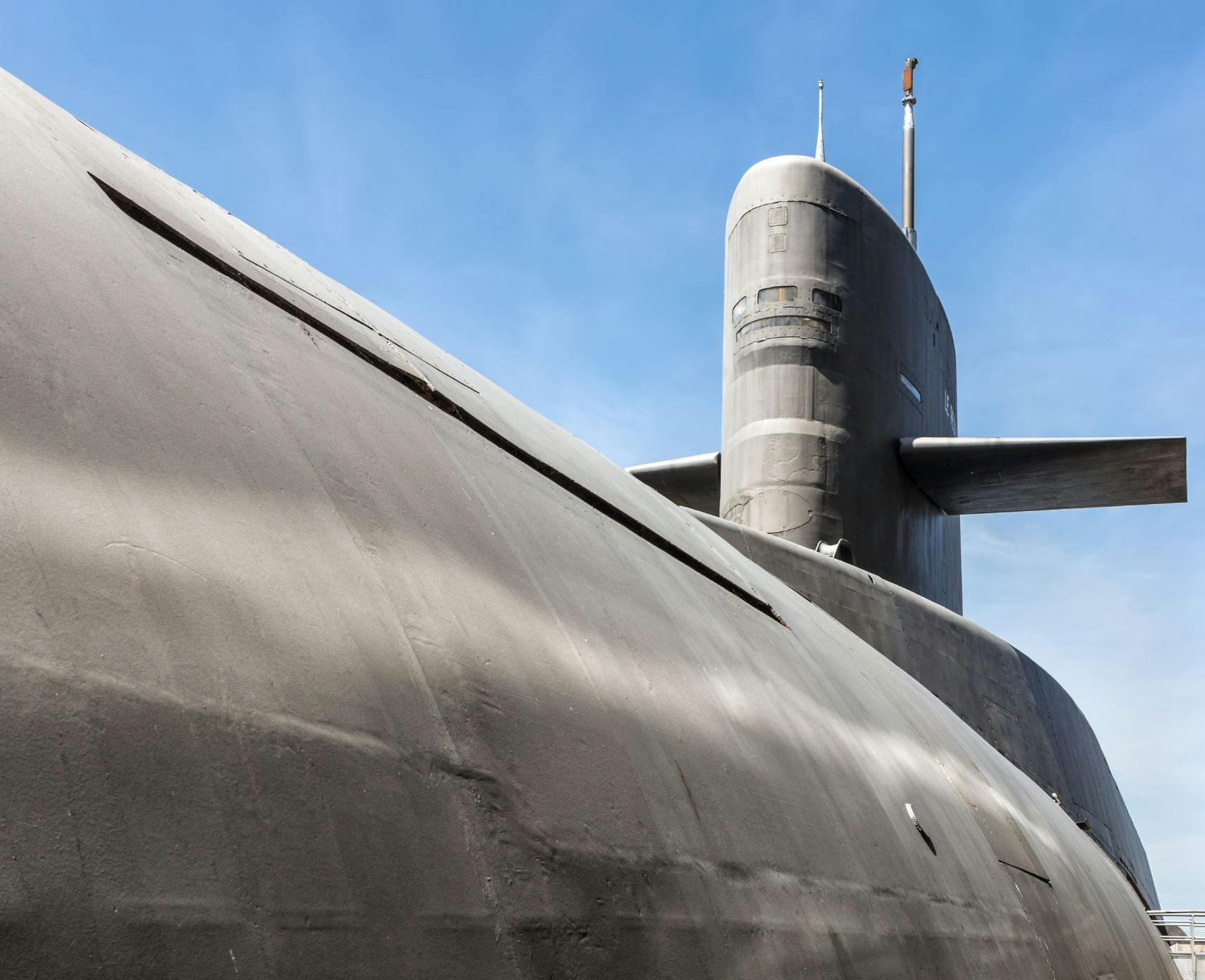 Top half of a nuclear submarine against a blue sky.